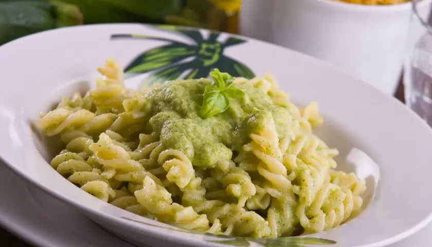 Pyszny makaron fusilli z kremowym sosem z cukinii, udekorowany listkiem bazylii. Idealny na szybki obiad.