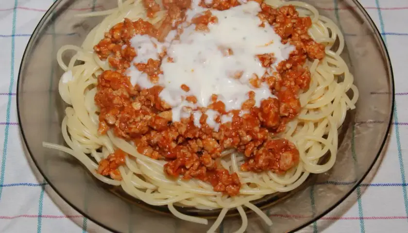Spaghetti z sosem bolognese. Mięso mielone doprawione do smaku, podane z makaronem i sosem śmietanowym.