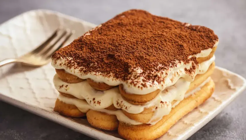 Pyszne tiramisu z kremem i biszkoptami, posypane kakao. Zastanawiasz się, jaki alkohol do tiramisu?