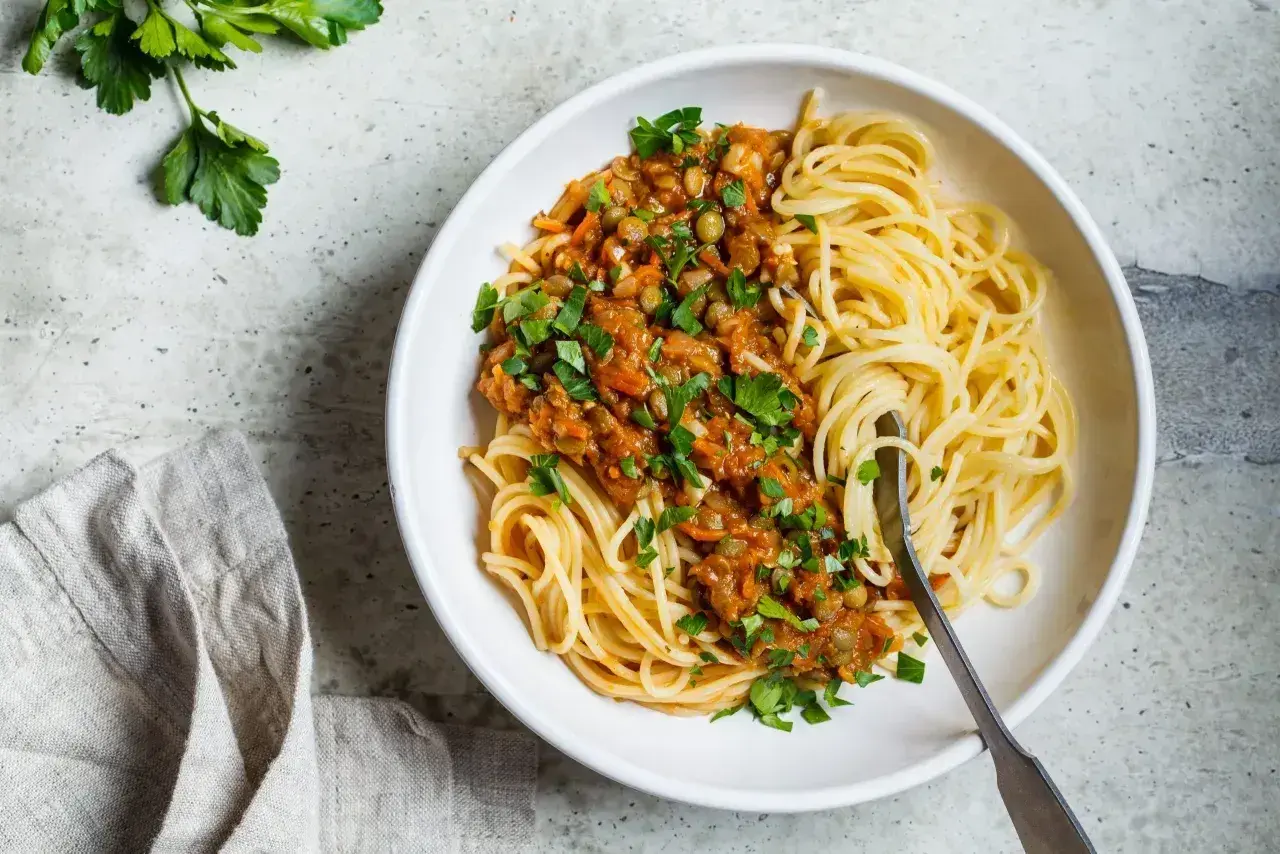 Porcja spaghetti z sosem z soczewicy i warzyw. Zastanawiasz się, ile węglowodanów ma makaron?