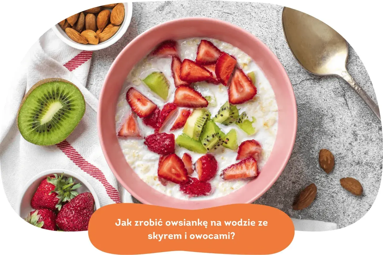 Pyszna owsianka z owocami: truskawkami i kiwi, podana w różowej miseczce. Obok migdały i łyżka.