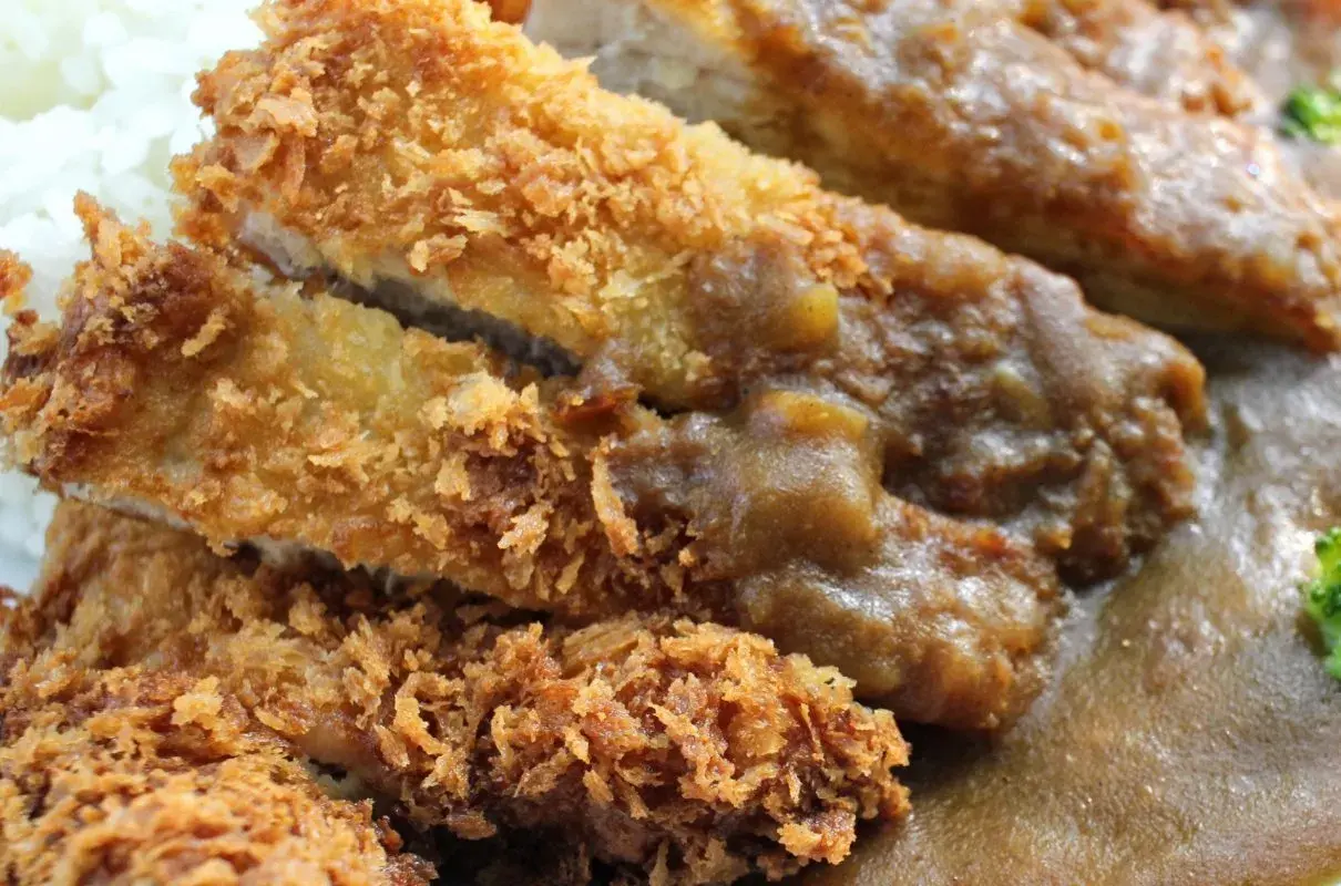 Chrupiący kurczak po japońsku, polany gęstym sosem curry, podany z ryżem. Pyszne danie!