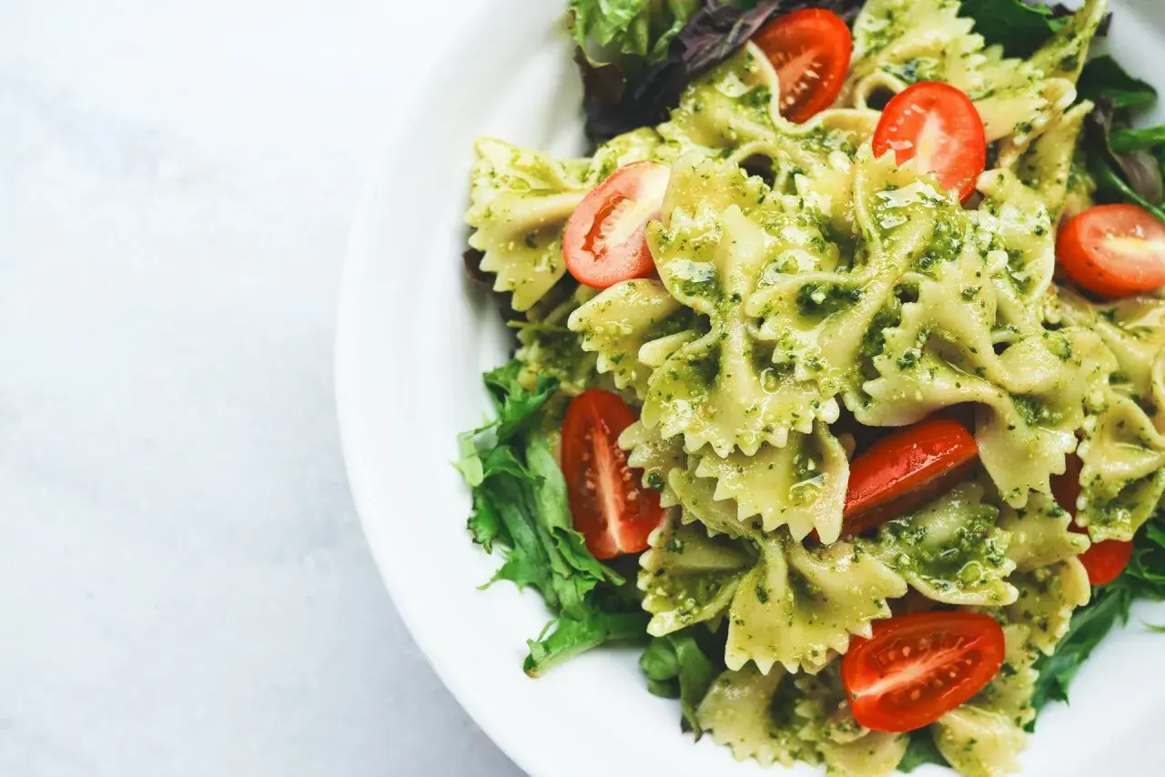 Pyszny obiad na redukcji: makaron farfalle z pesto, pomidorkami koktajlowymi i świeżą sałatą. Lekko i zdrowo!