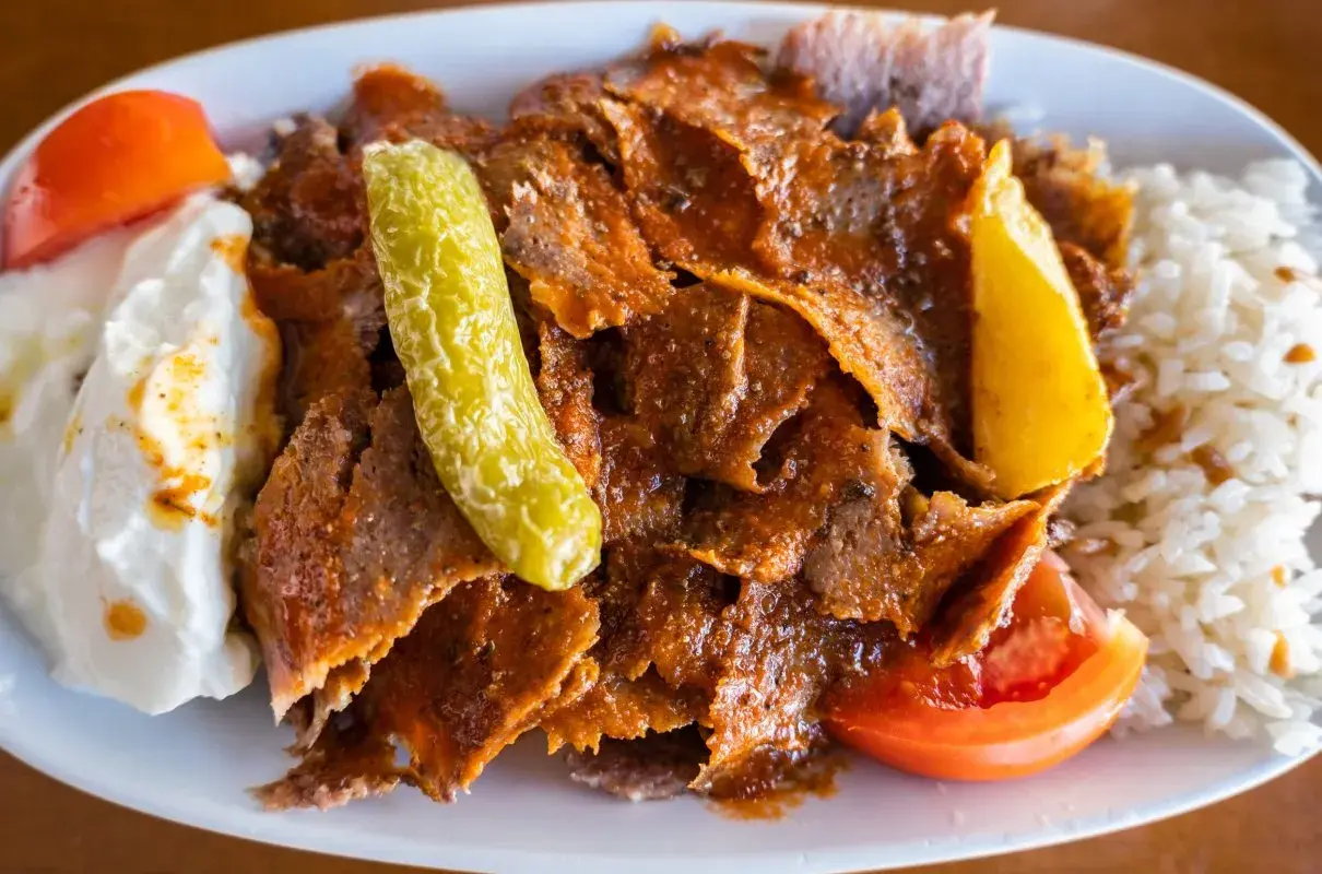 Pyszny kebab z mięsa mielonego z ryżem, jogurtem, pomidorem i ogórkiem.