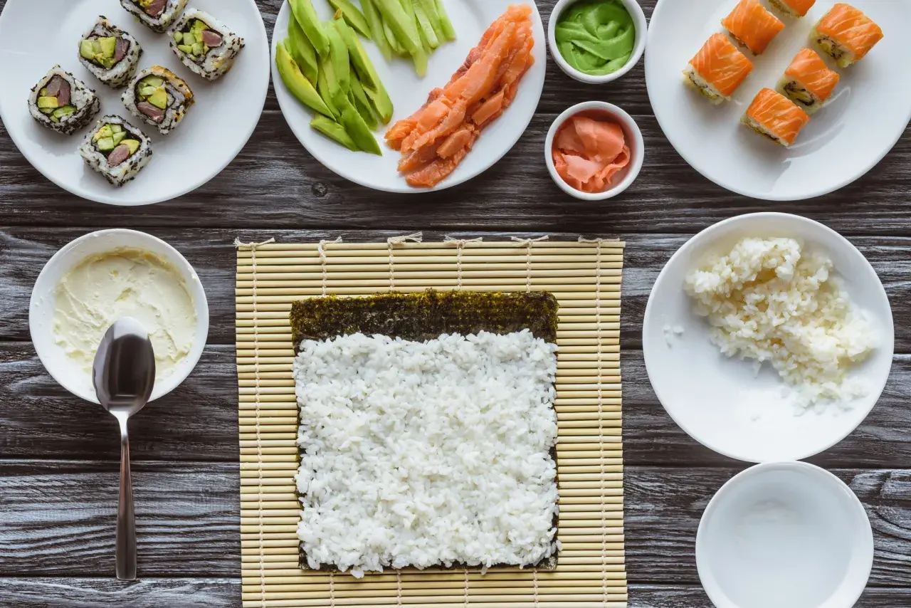 Składniki do sushi i risotto: ryż, łosoś, awokado, nori, wasabi, imbir, serek.