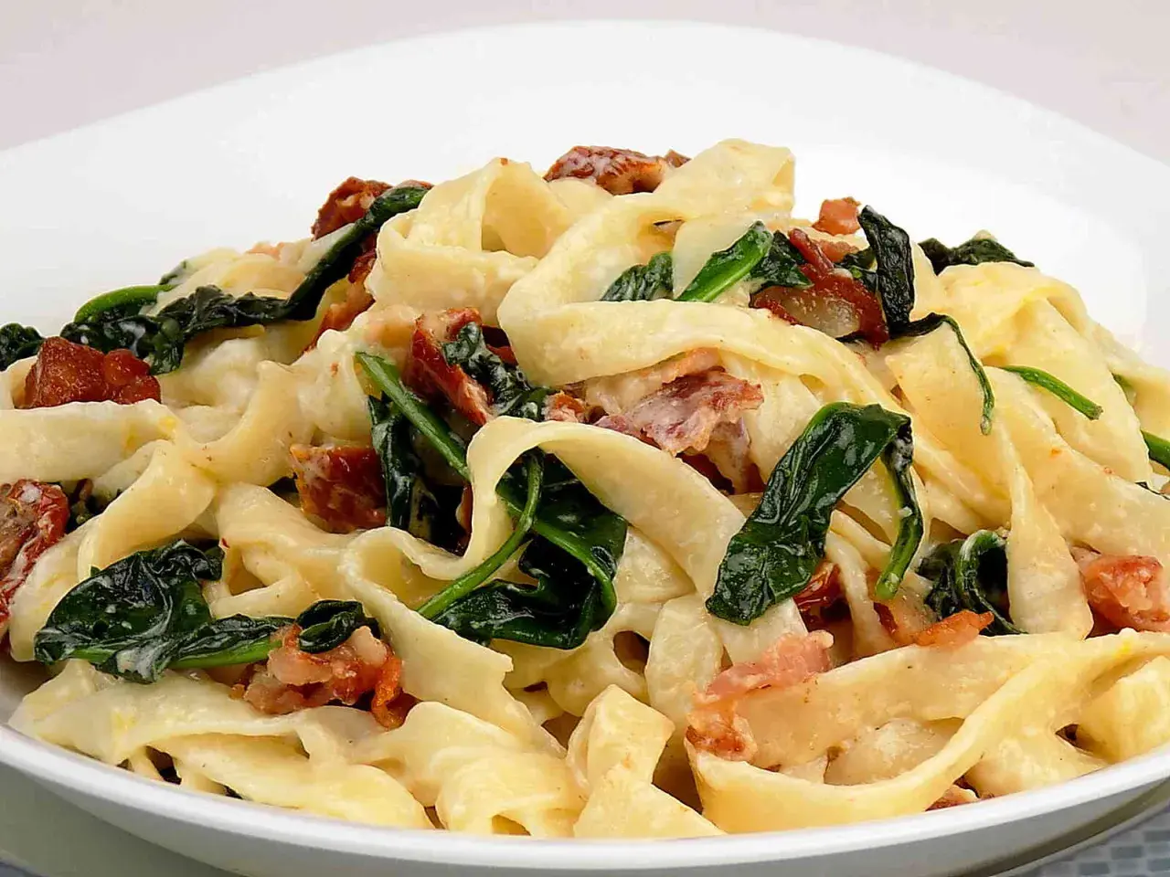Pappardelle z boczkiem i szpinakiem w kremowym sosie z mascarpone. Pyszne danie, które zachwyci każdego smakosza.