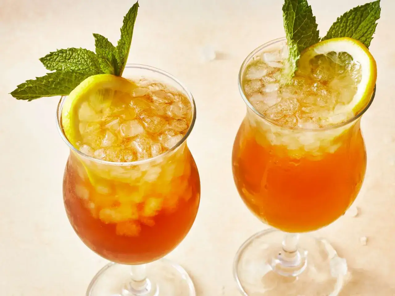 Dwa orzeźwiające drinki z lodem, plasterkiem cytryny i miętą, idealne na upalny dzień na Long Island.