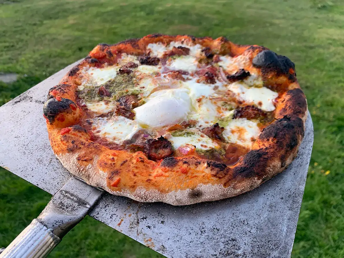 Pyszna pizza włoska przepis na idealny wieczór. Złociste ciasto, roztopiony ser i jajko na wierzchu.
