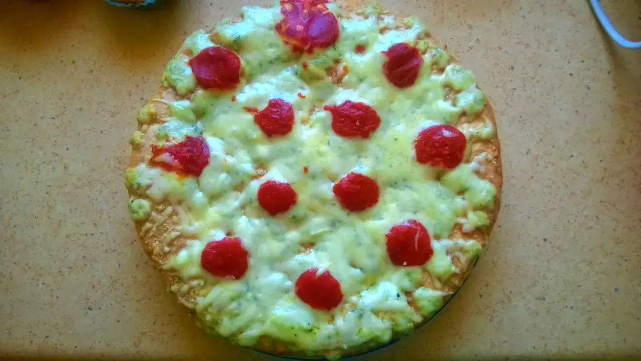Pyszna pizza Guiseppe 4 sery z zielonym pesto i czerwonymi pomidorkami.