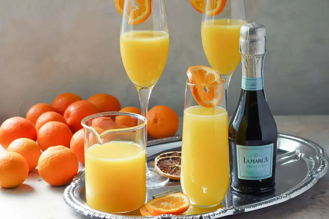 Szykowna mimosa z prosecco La Marca i świeżymi pomarańczami na srebrnej tacy.