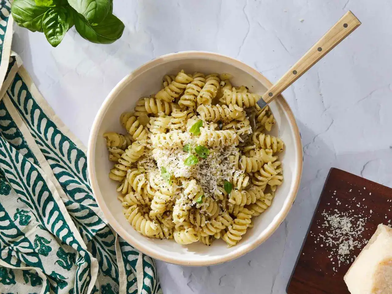 Pyszny makaron z pesto ze słoika, posypany parmezanem i świeżą bazylią. Idealny na szybki obiad.