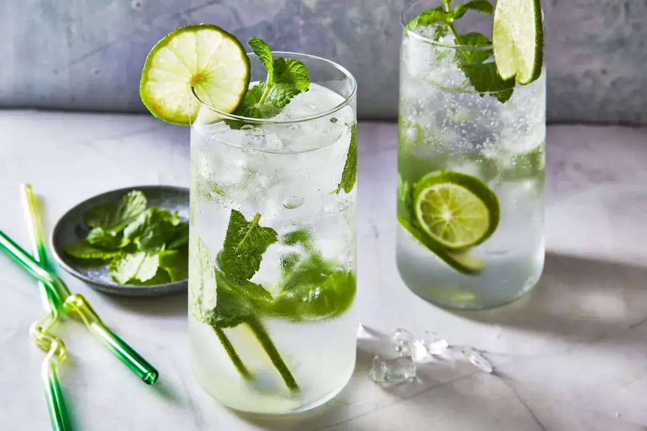 Dwa orzeźwiające mojito z lodem, miętą i limonką, gotowe do degustacji.