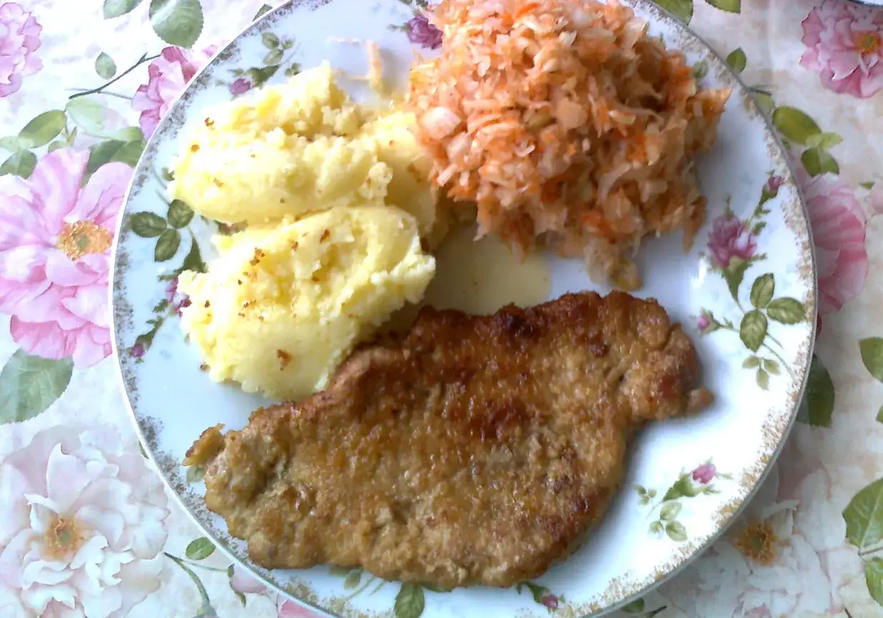 Pyszne dania na obiad: panierowany kotlet, purée ziemniaczane i surówka z marchewki i kapusty.