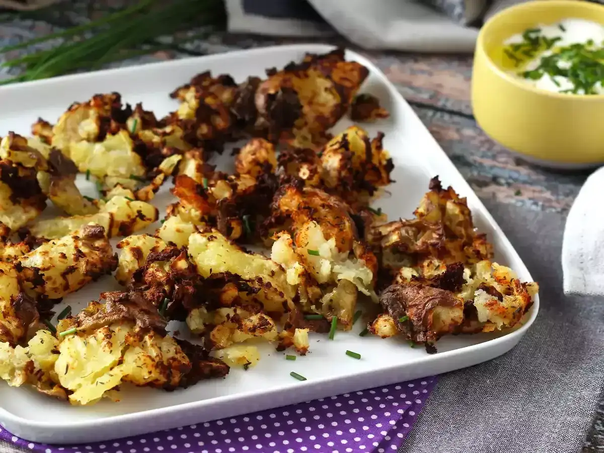 Chrupiące ziemniaki z airfryera, idealne do wypróbowania z naszymi airfryer przepisami po polsku. Podane z jogurtem i szczypiorkiem.