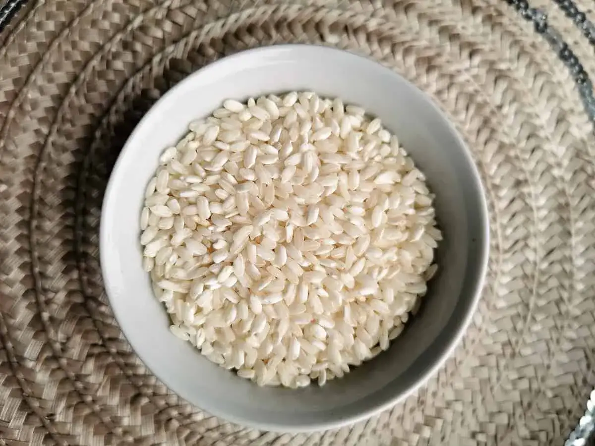Biały ryż do risotto w miseczce, gotowy do przygotowania kremowego dania.